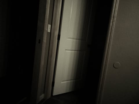 A dark doorway with light spilling through the gap